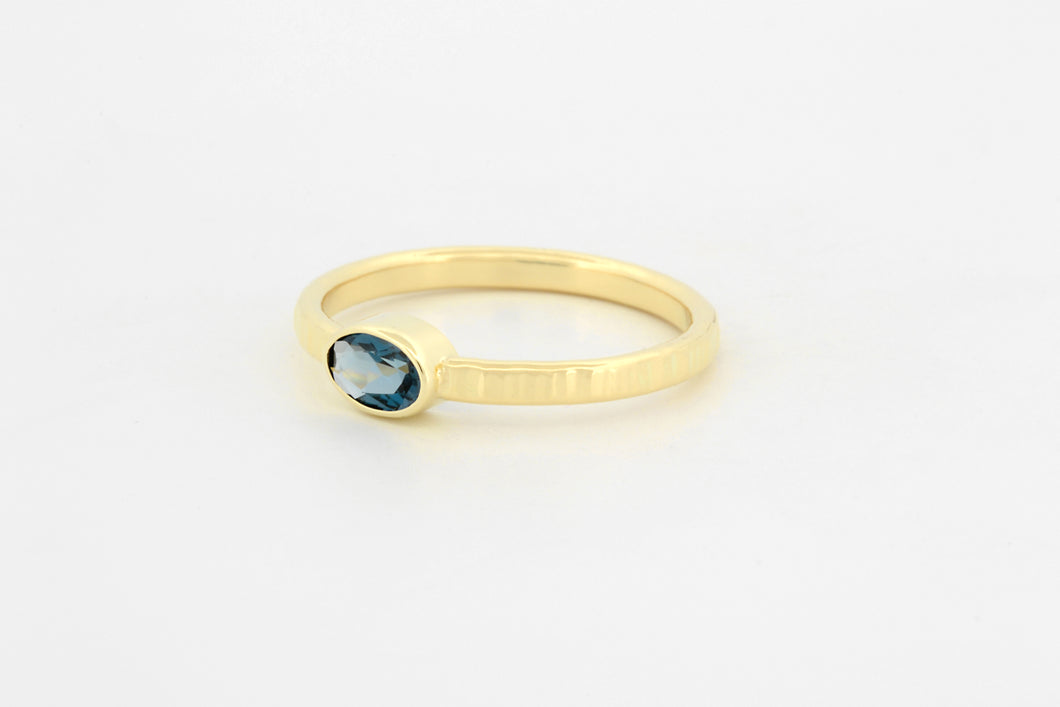 Ring met hamerslag en blauwe topaas ovaal, geelgoud
